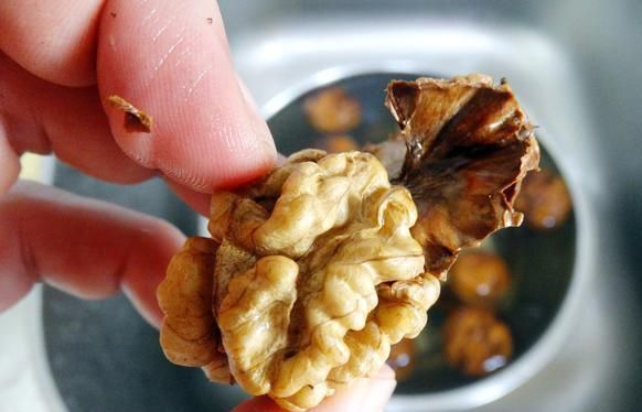 Remove walnut peel manually